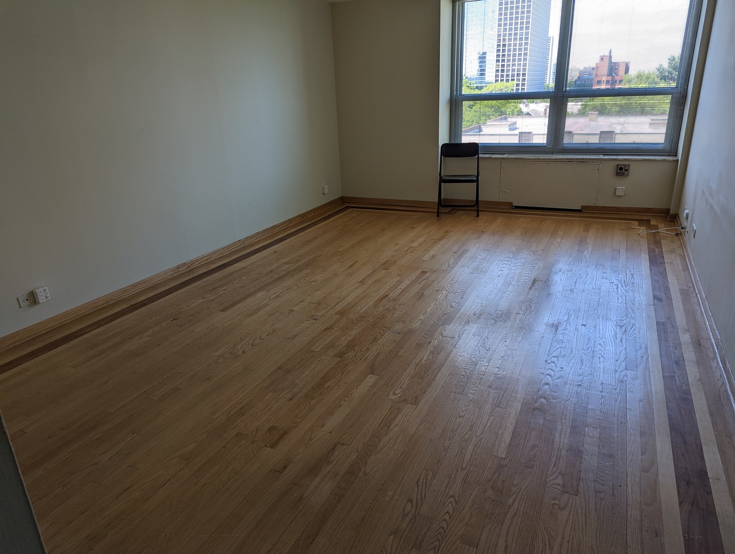720 West Gordon Terrace, Unit 7J Chicago, IL 60613 - Photo 2 of 14 an empty room with wooden floor and windows