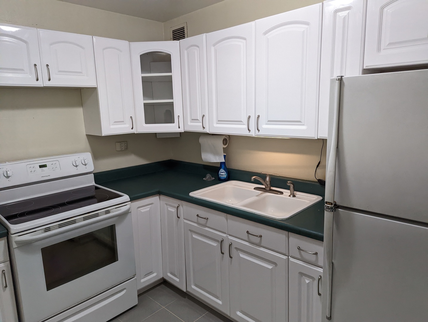 720 West Gordon Terrace, Unit 7J Chicago, IL 60613 - Photo 5 of 14 a kitchen with granite countertop white cabinets and white appliances