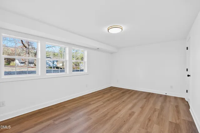a view of a room with wooden floor and white walls
