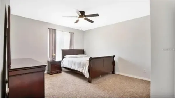 a bedroom with a bed and a ceiling fan