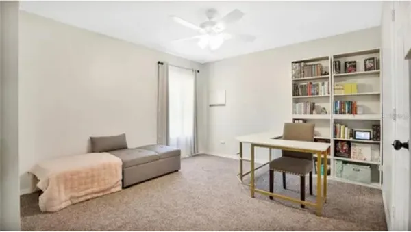 a living room with furniture and a book shelf