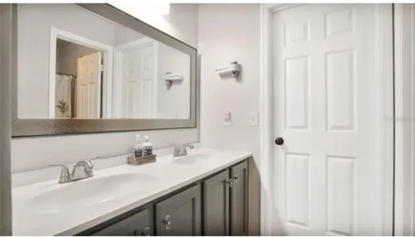 a bathroom with a double vanity sink and a mirror