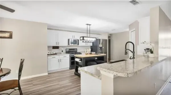 a kitchen with a sink cabinets and wooden floor
