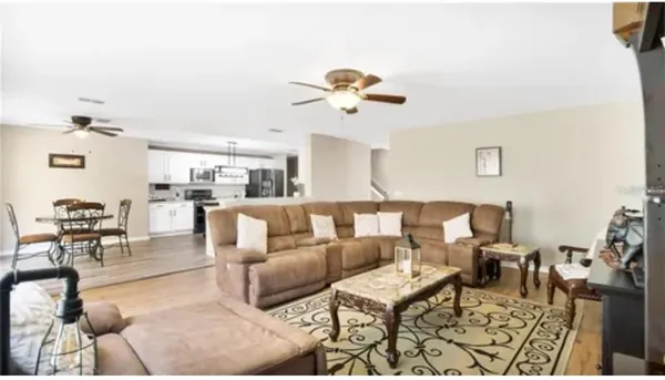 a living room with lots of furniture and view of kitchen