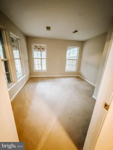 a view of an empty room with a fireplace and a window