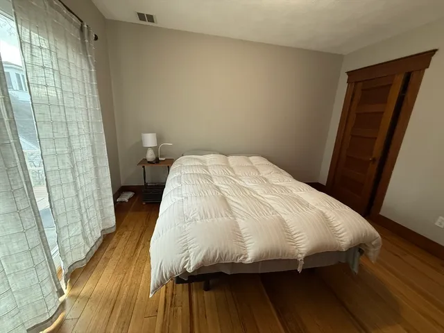 a bed sitting in a bedroom next to a window