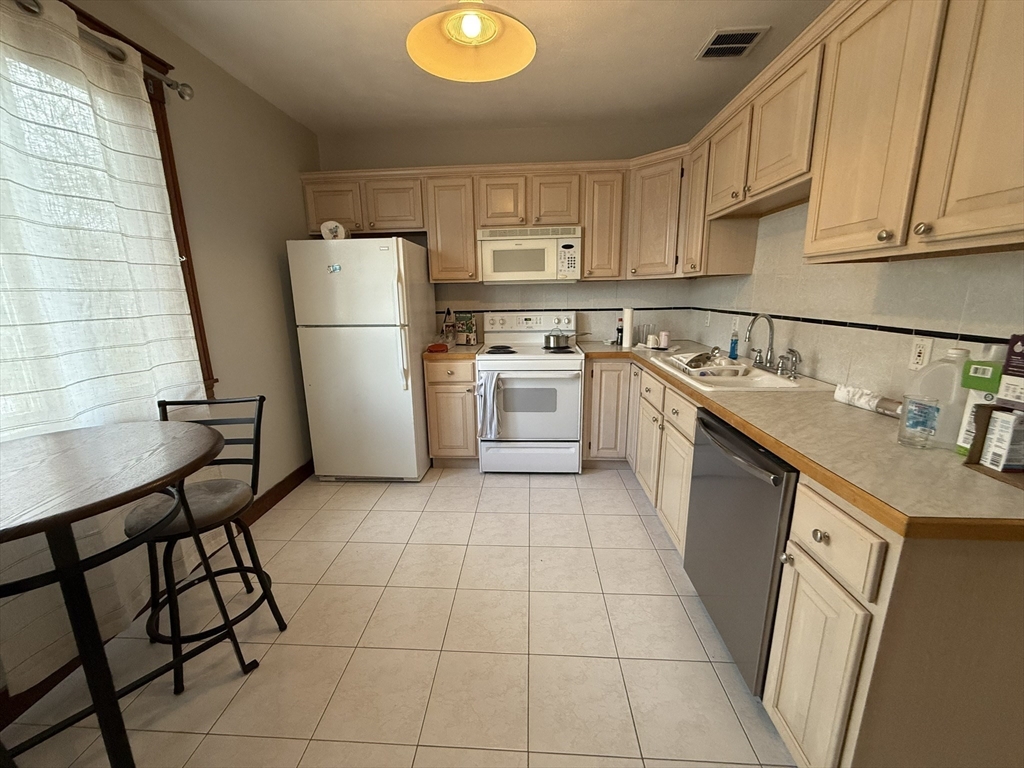 22 Yale Avenue, Unit A Wakefield, MA 01880 - Photo 12 of 23 a kitchen with a sink a stove a refrigerator and cabinetry