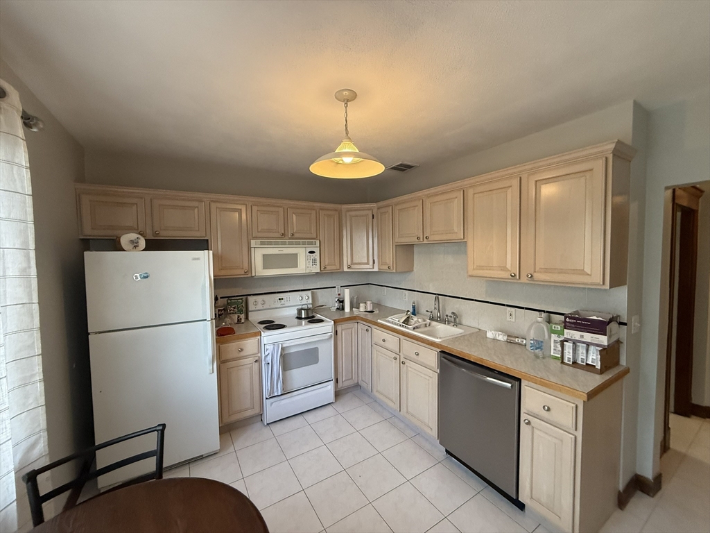 22 Yale Avenue, Unit A Wakefield, MA 01880 - Photo 14 of 23 a kitchen with appliances a sink and a refrigerator