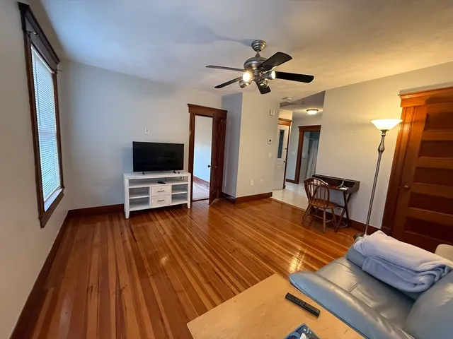 a living room with furniture flat screen tv and a wooden floor