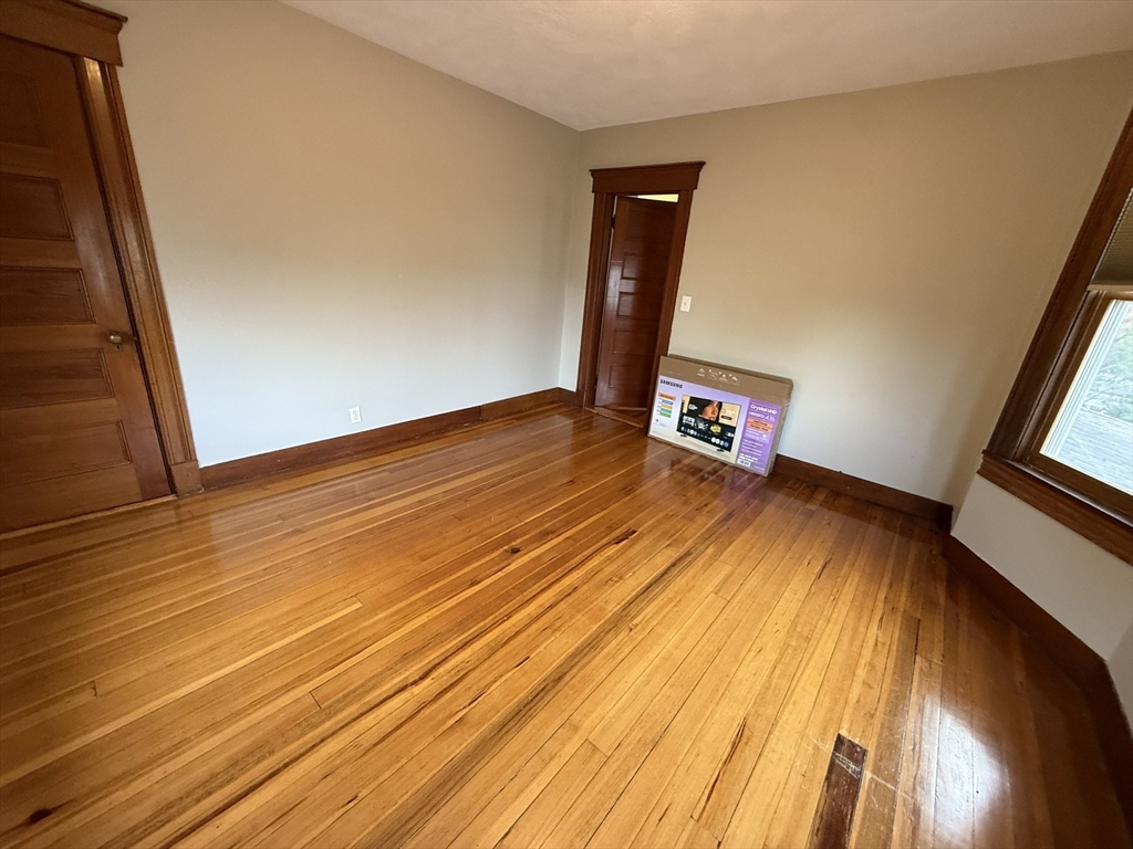22 Yale Avenue, Unit A Wakefield, MA 01880 - Photo 6 of 23 a view of an empty room with wooden floor and a window