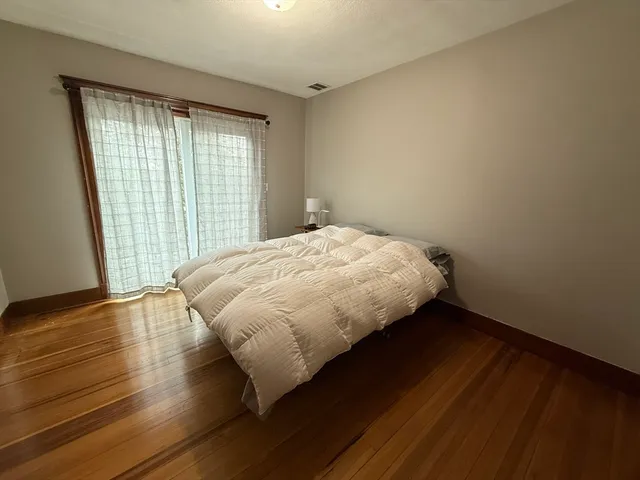 a bed sitting in a bedroom next to a window
