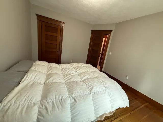 a bed sitting in a bedroom next to a cabinet