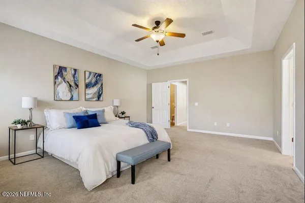 a spacious bedroom with a bed and a ceiling fan