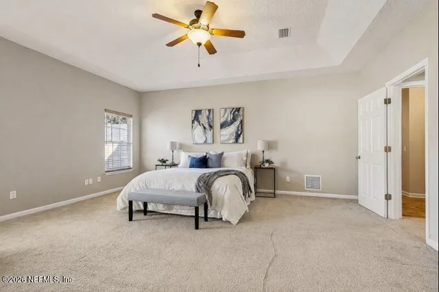 a spacious bedroom with a bed and a chandelier