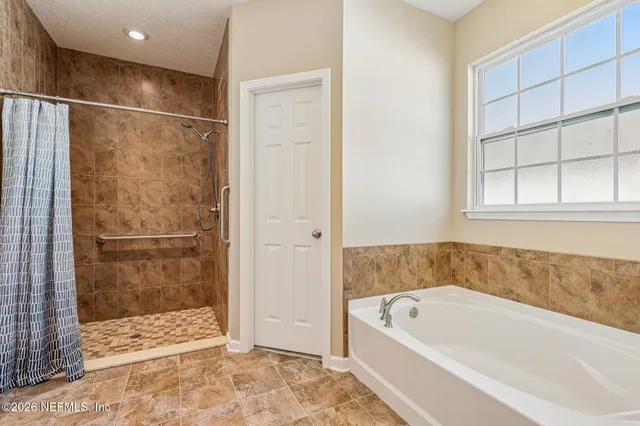 a bathroom with a tub sink and mirror