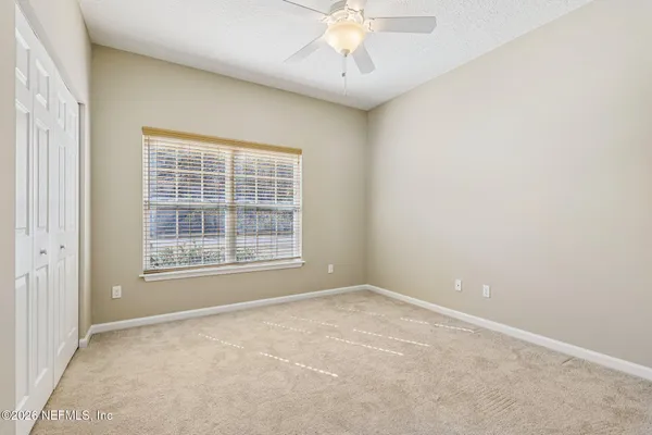 a spacious bedroom with a bed and a large window