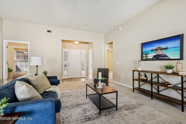 a living room with furniture a rug and a painting on the wall