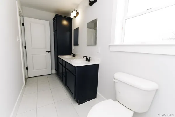 a bathroom with a sink a toilet and mirror