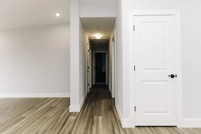 a view of a hallway with wooden floor