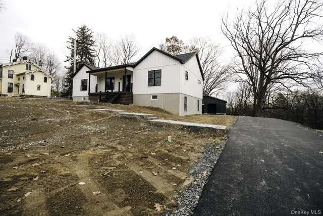 a view of a white house with a yard covered in snow