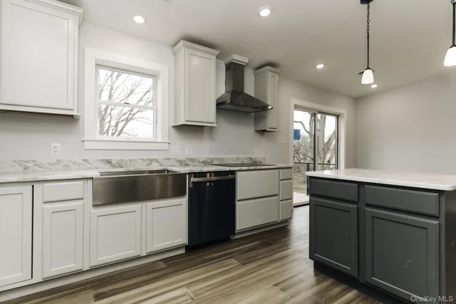 a kitchen with stainless steel appliances granite countertop a sink a stove and a wooden floors