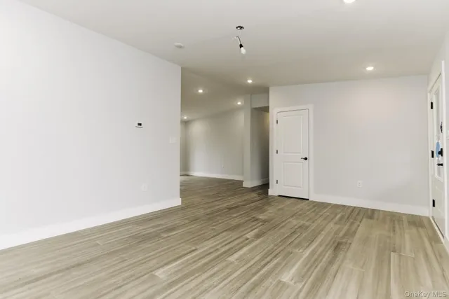 a view of an empty room with wooden floor