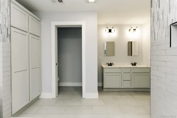 a bathroom with a double vanity sink a mirror and a bathtub