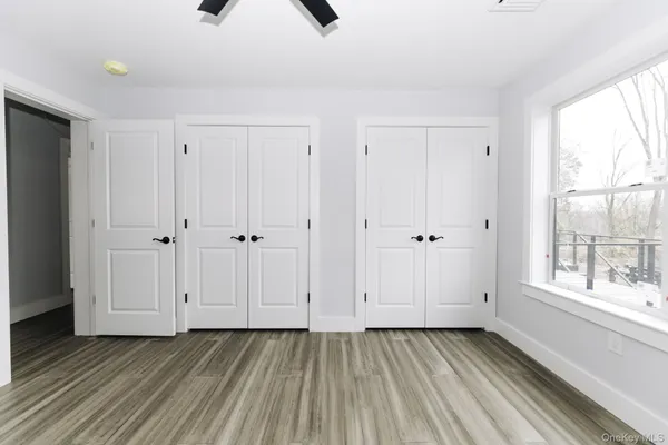 a view of an empty room with window and closet area
