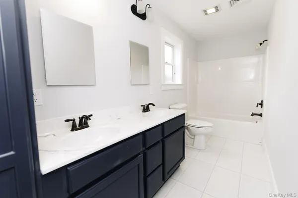 a bathroom with a sink a toilet a mirror and shower