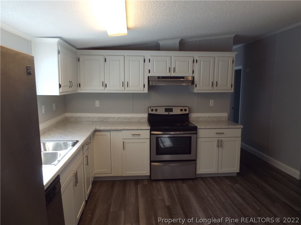 73 Georgia Way Cameron, NC 28326 - Photo 13 of 28 a kitchen with a white stove top oven and white cabinets