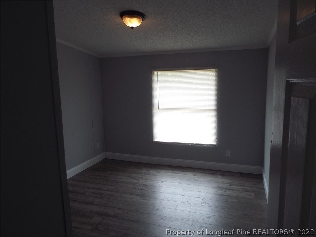 73 Georgia Way Cameron, NC 28326 - Photo 17 of 28 an empty room with wooden floor and windows