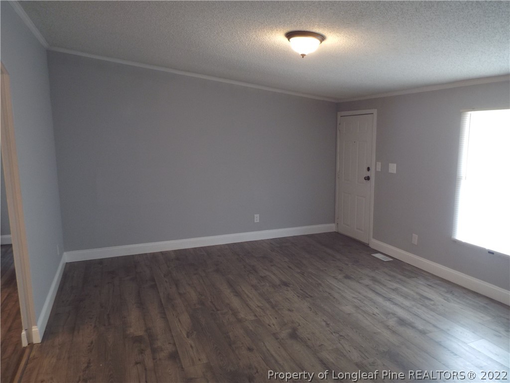 73 Georgia Way Cameron, NC 28326 - Photo 6 of 28 an empty room with wooden floor and windows