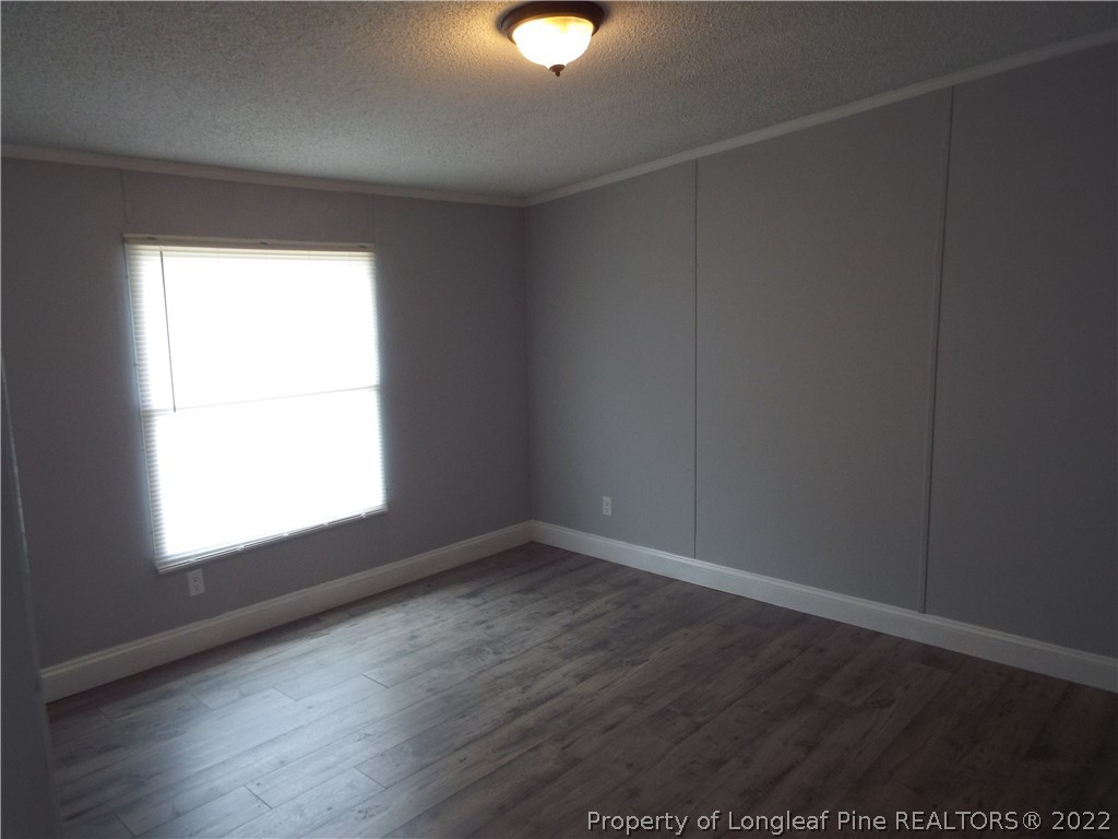 73 Georgia Way Cameron, NC 28326 - Photo 9 of 28 an empty room with wooden floor and windows
