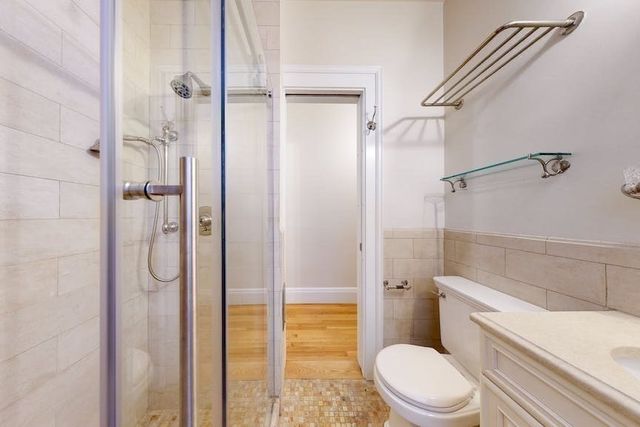 a bathroom with a granite countertop toilet a sink and shower