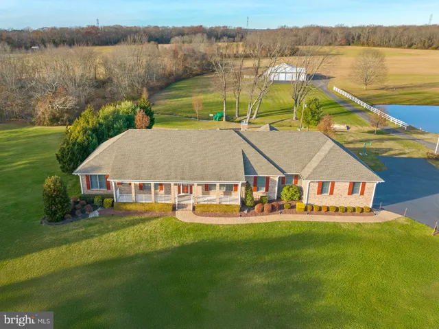 an aerial view of a house with swimming pool and green space