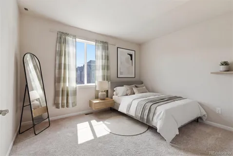 a bedroom with a bed and a large window