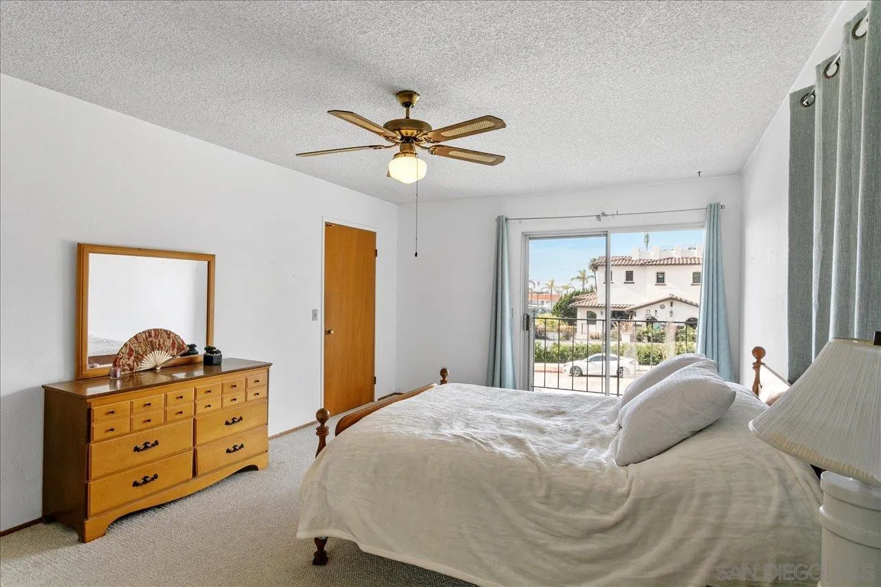 1221 Virginia Way La Jolla, CA 92037 - Photo 15 of 27 a bedroom with a bed and a chandelier