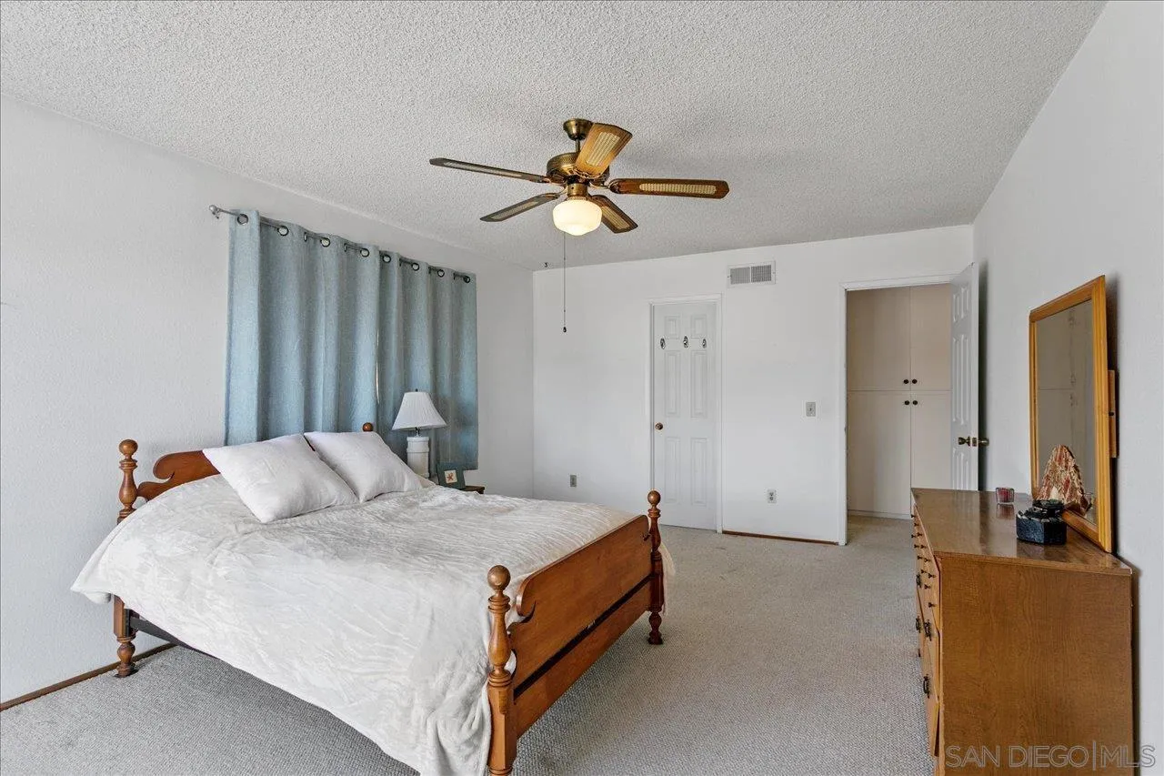 1221 Virginia Way La Jolla, CA 92037 - Photo 16 of 27 a bedroom with a bed and a chandelier