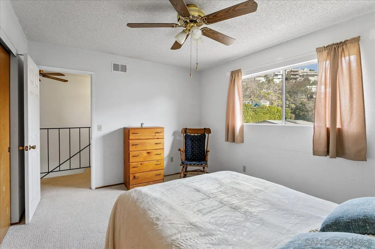 1221 Virginia Way La Jolla, CA 92037 - Photo 19 of 27 a bedroom with a bed and a large window