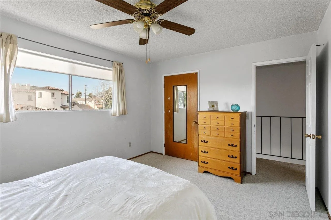1221 Virginia Way La Jolla, CA 92037 - Photo 21 of 27 a bedroom with a bed and a chandelier