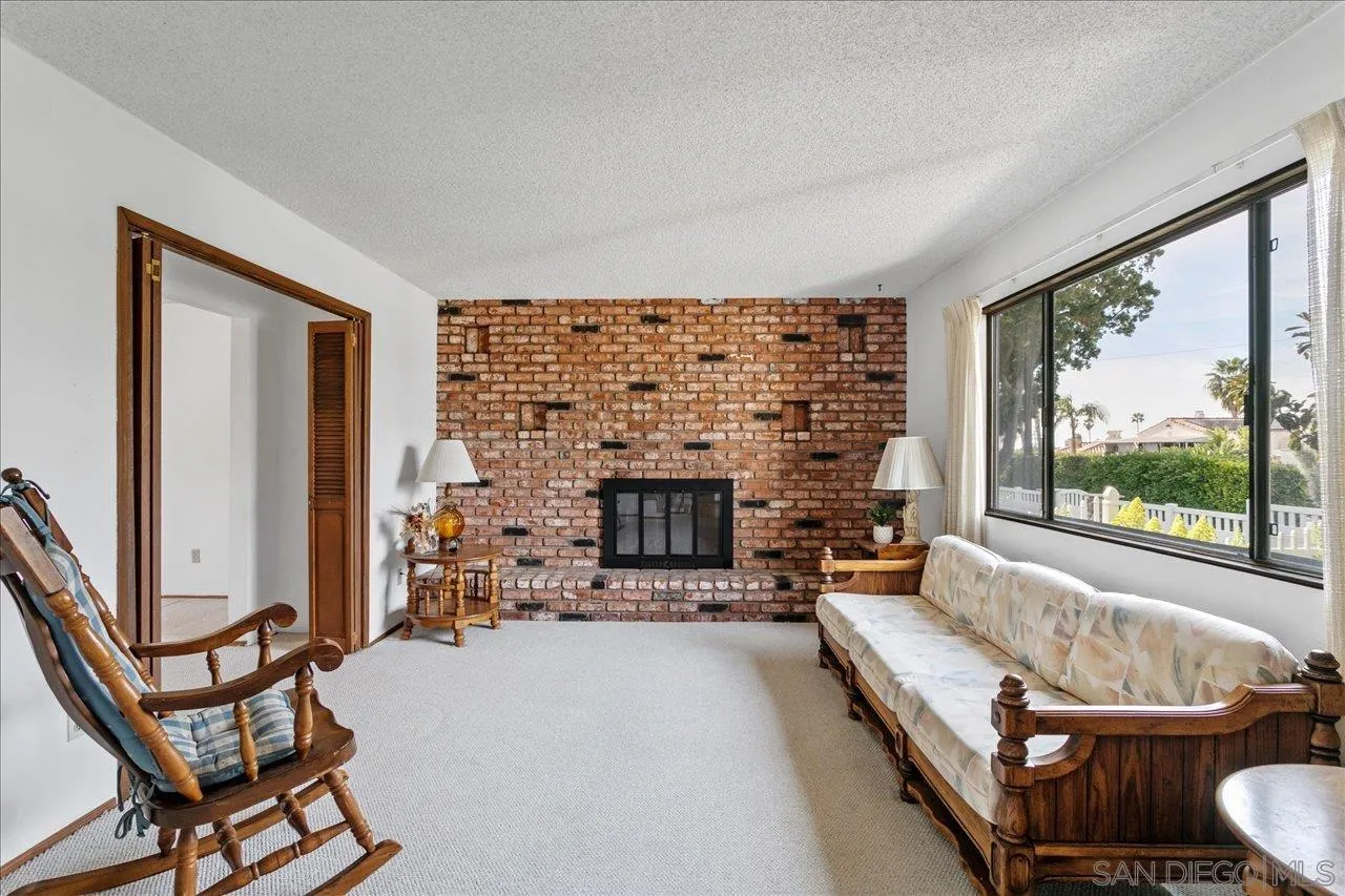1221 Virginia Way La Jolla, CA 92037 - Photo 5 of 27 a living room with furniture a fireplace and a floor to ceiling window