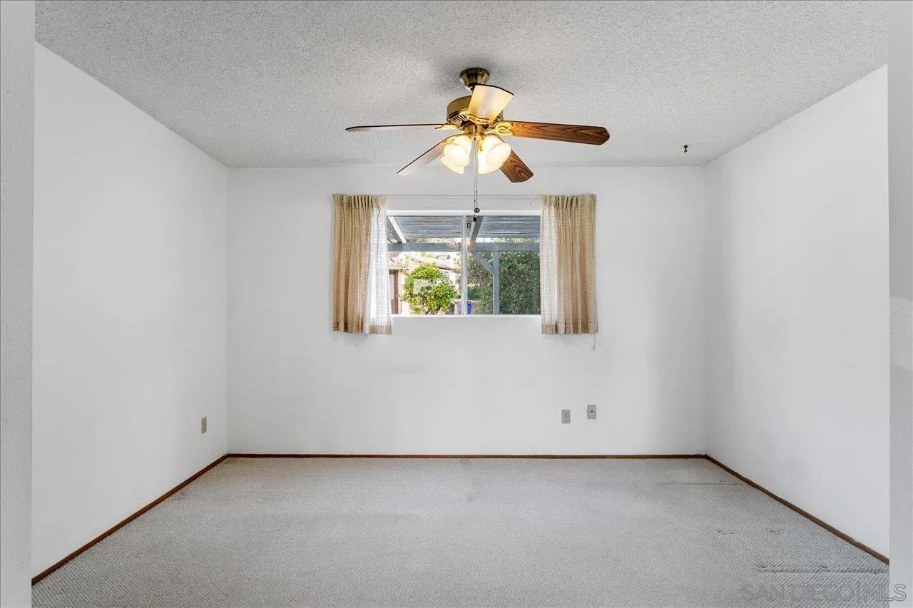 1221 Virginia Way La Jolla, CA 92037 - Photo 8 of 27 an empty room with windows and fan