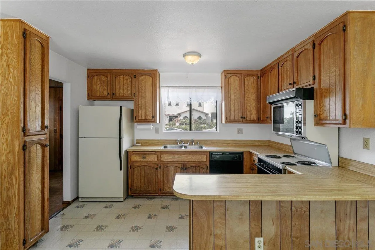 1221 Virginia Way La Jolla, CA 92037 - Photo 10 of 27 a kitchen with stainless steel appliances granite countertop a refrigerator a stove a sink and a microwave