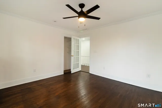 a view of an empty room with window and wooden floor