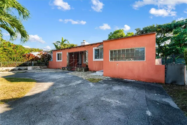 a view of a house with backyard and sitting area