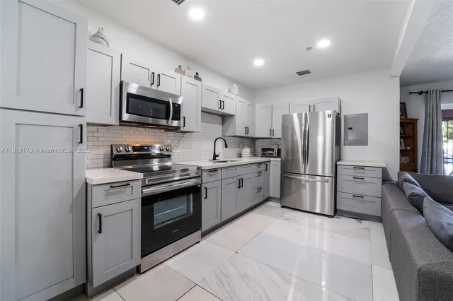a kitchen with stainless steel appliances a refrigerator stove microwave and sink