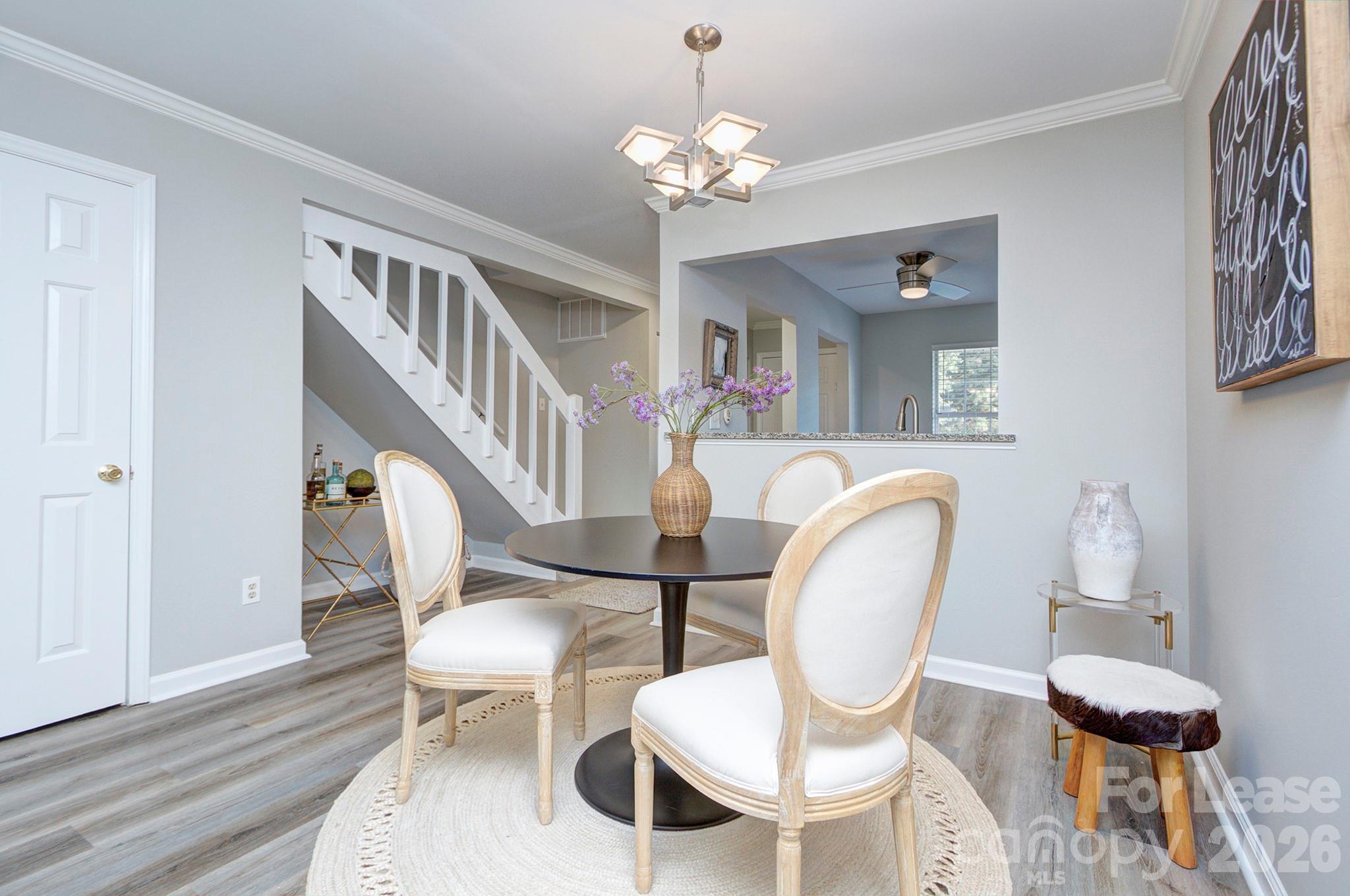 8268 Golf Ridge Drive Charlotte, NC 28277 - Photo 9 of 24 a dining room with wooden floor a chandelier a glass table and chairs