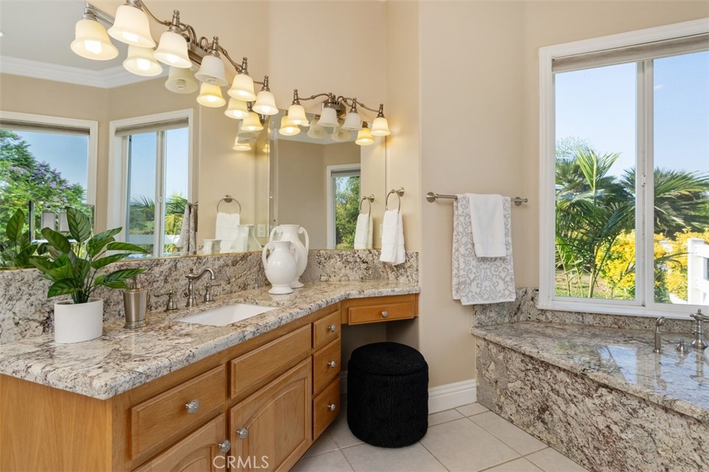 23505 Carancho Road Temecula, CA 92590 - Photo 27 of 73 a bathroom with a granite countertop sink a large mirror and a shower