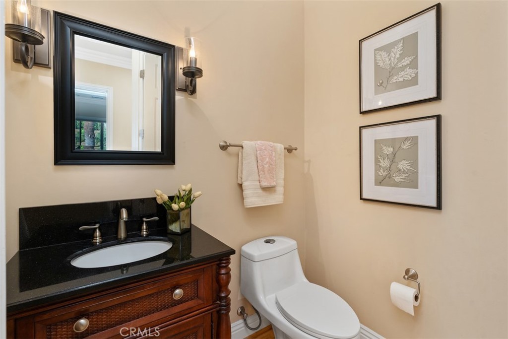 23505 Carancho Road Temecula, CA 92590 - Photo 32 of 73 a bathroom with a toilet a sink and mirror