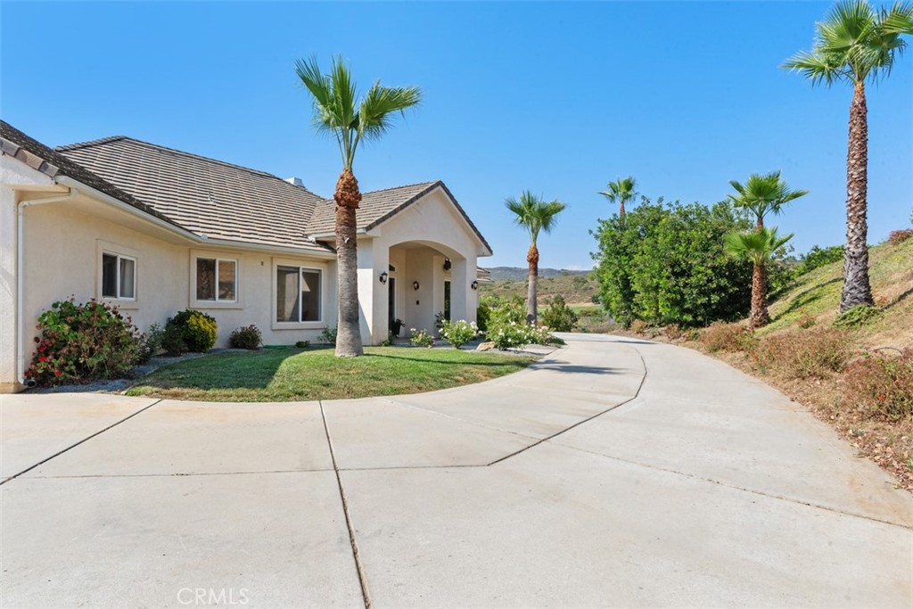 23505 Carancho Road Temecula, CA 92590 - Photo 66 of 73 a front view of a house with a yard and potted plants
